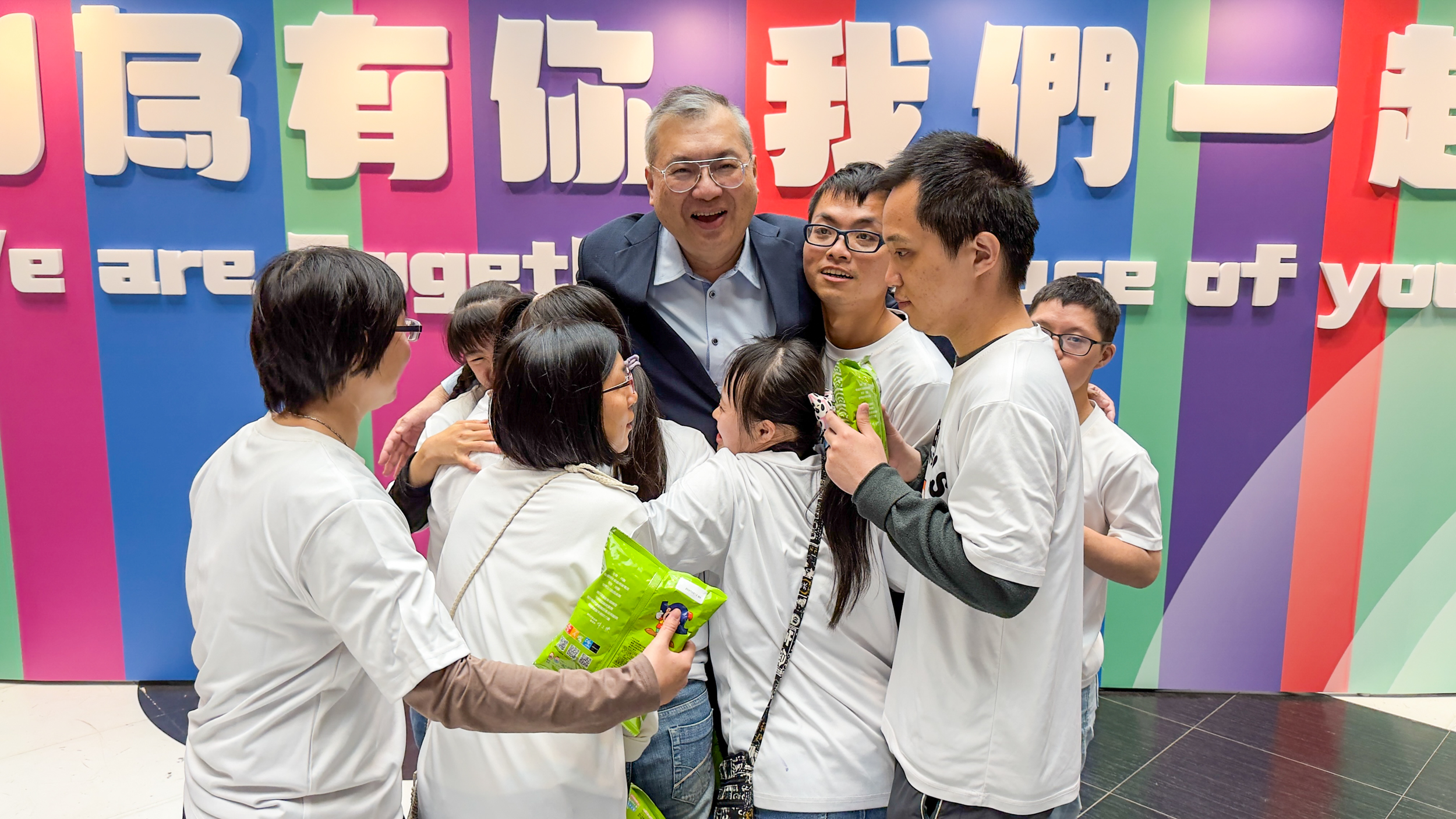 世界唐氏症日活動中溫暖互動與擁抱畫面，展現對唐氏症家庭的關懷與支持，並透過祈福商品支持庇護就業